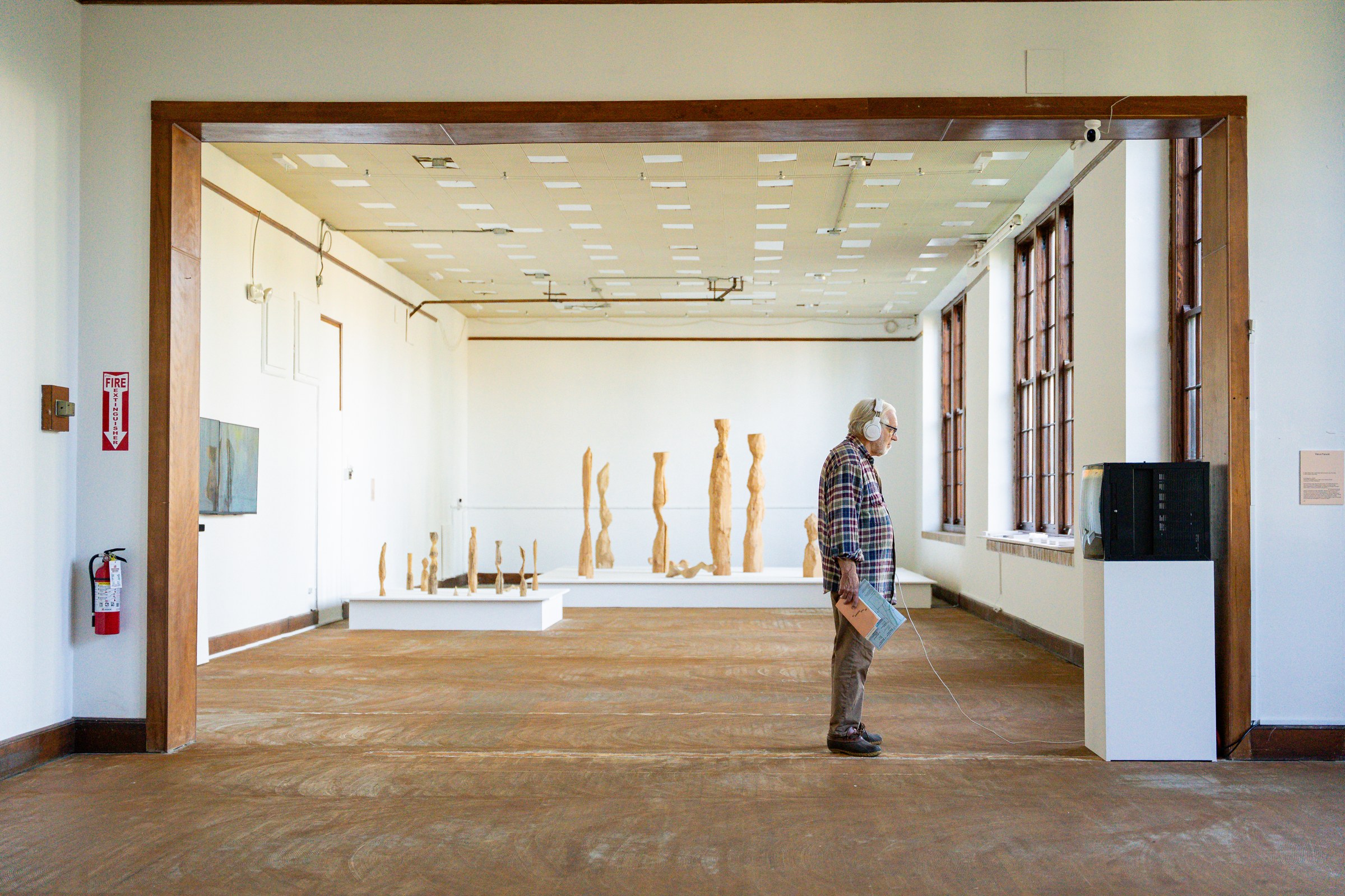 A visitor at the former Medina High School with Aki Inomata’s sculptural installation visible beyond