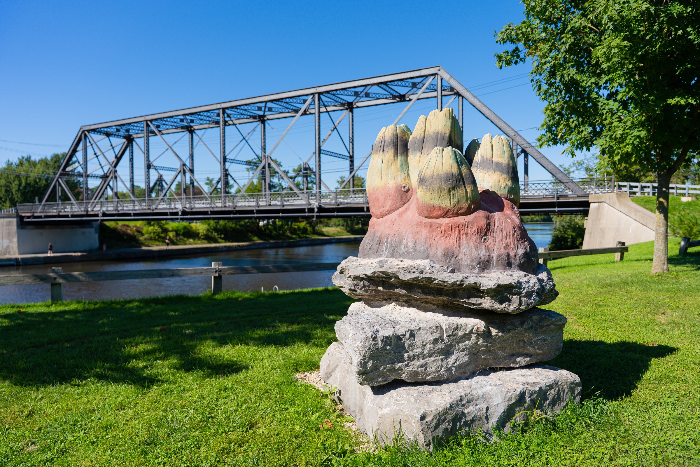 Anne Duk Hee Jordan’s sculpture on stacked stone beside the Erie Canal and bridge